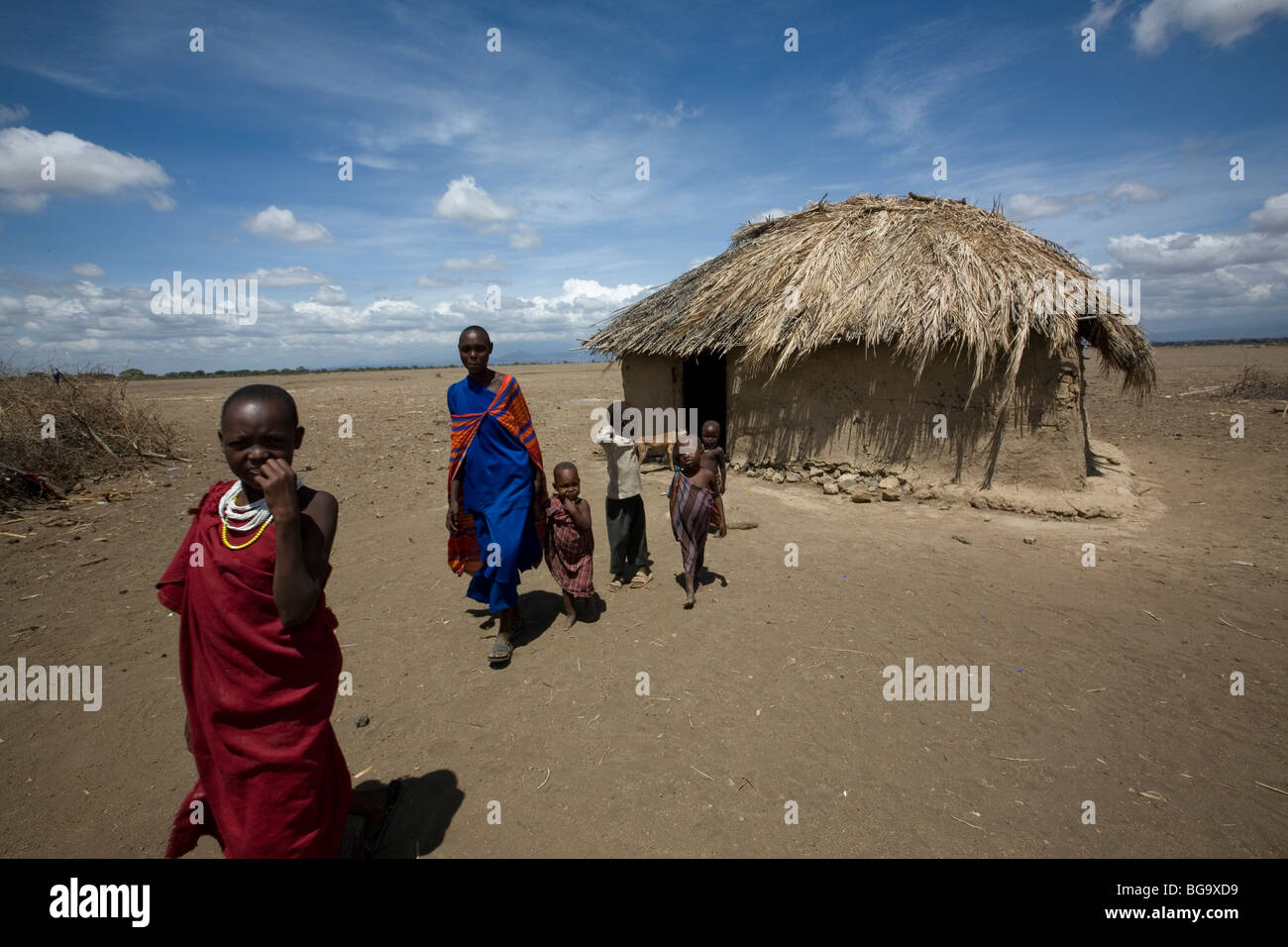 Una famiglia Masai esce dalla loro casa nel villaggio di Tindagani, regione di Kilimanjaro, Tanzania Africa Orientale. Foto Stock