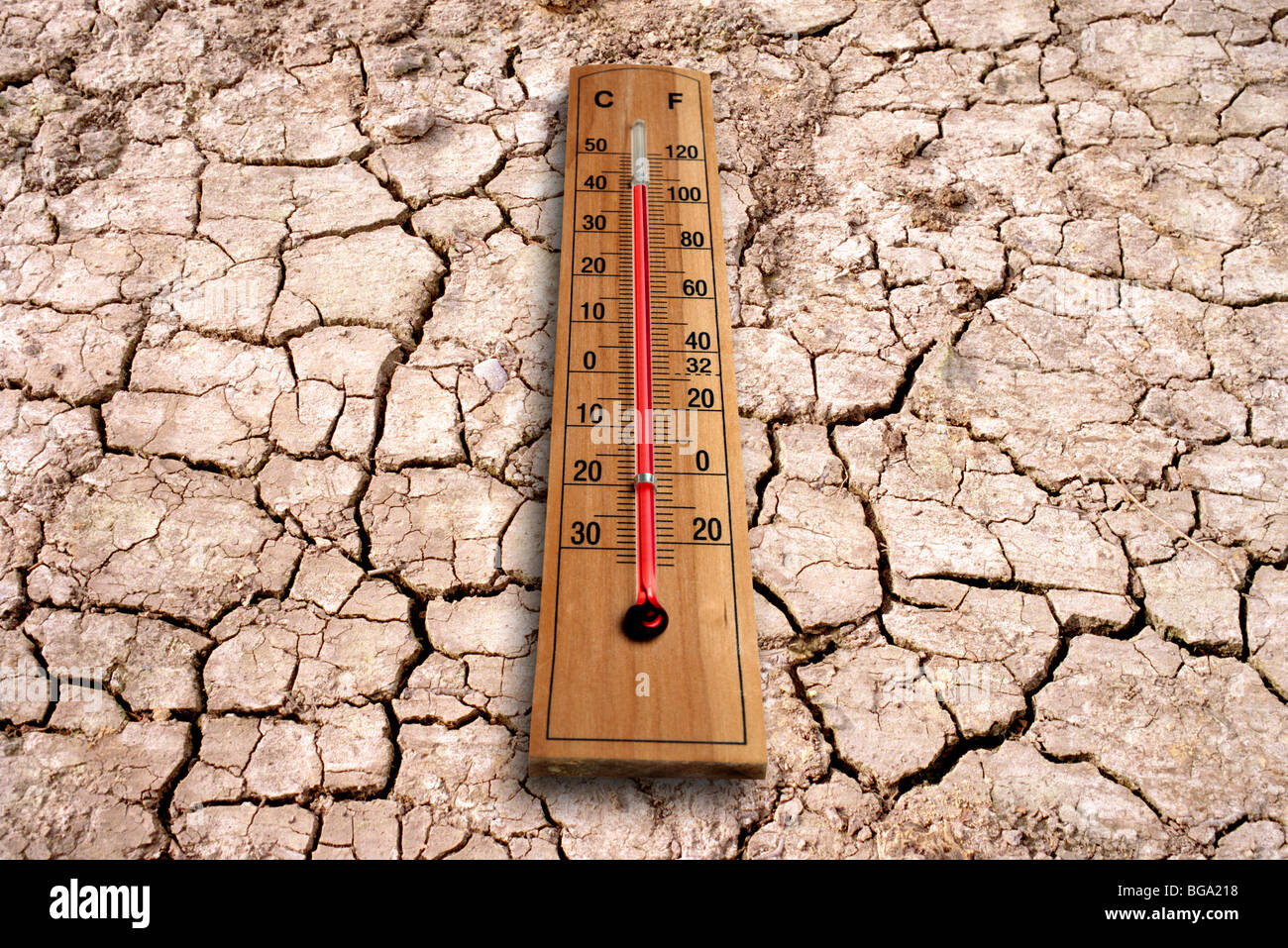 Termometro e fango incrinato che rappresenta il pianeta sempre più caldo dal cambiamento climatico. Foto Stock