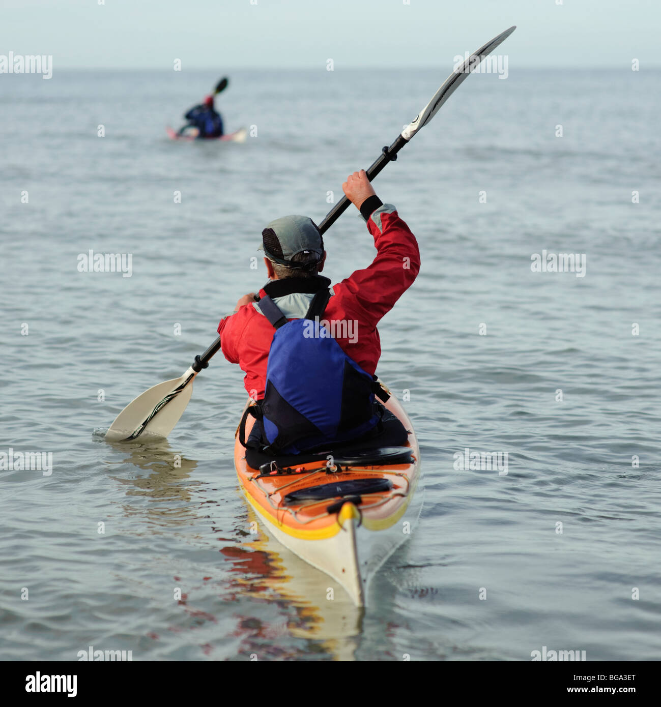 Vista posteriore di due uomini adulti persone canoa kayak da mare, su un'attività casa vacanza sull'oceano, REGNO UNITO Foto Stock