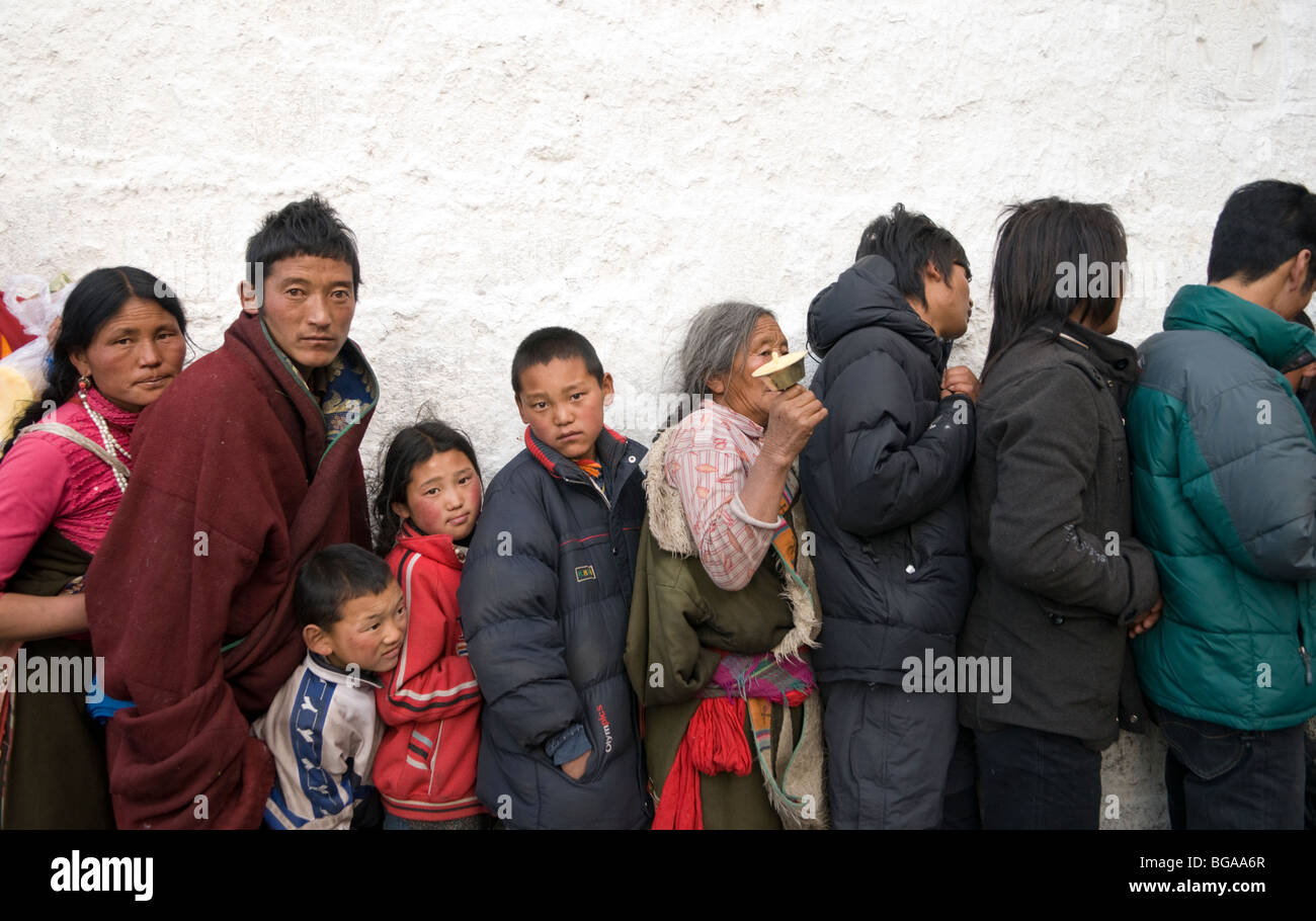 I pellegrini in attesa in fila per ore per inserire il sacro tempio di Jokhang a Lhasa il Tibet Foto Stock