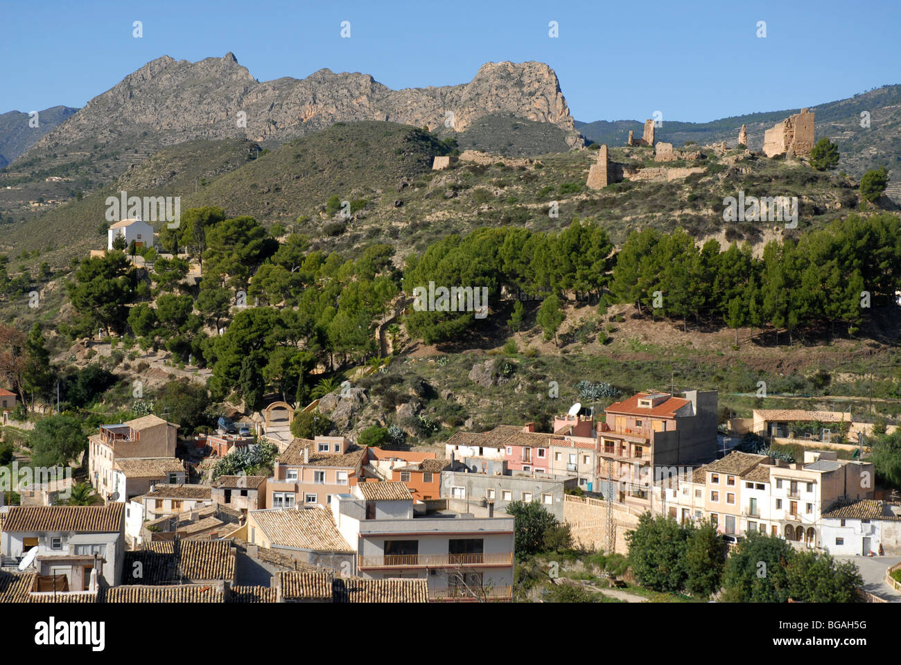 Vista sul borgo con il castello in rovina dietro, Relleu, Provincia di Alicante, Comunidad Valenciana, Spagna Foto Stock