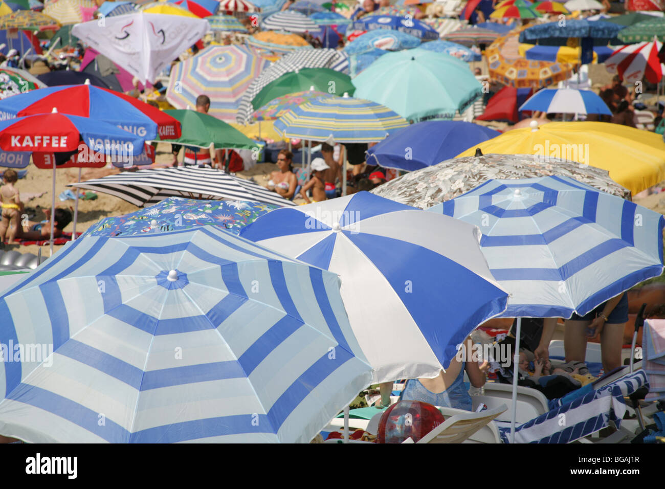 La Croazia. Isola di Rab. Umbrelas sulla spiaggia. Spiaggia affollata. Foto Stock