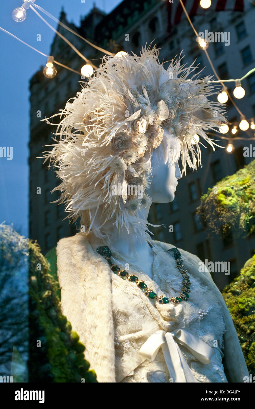 Elegante bellezza bianco indossando smeraldi tra topiaria da bestie in un Bergdorf Goodman finestra di Natale Fifth Avenue di New York City Foto Stock