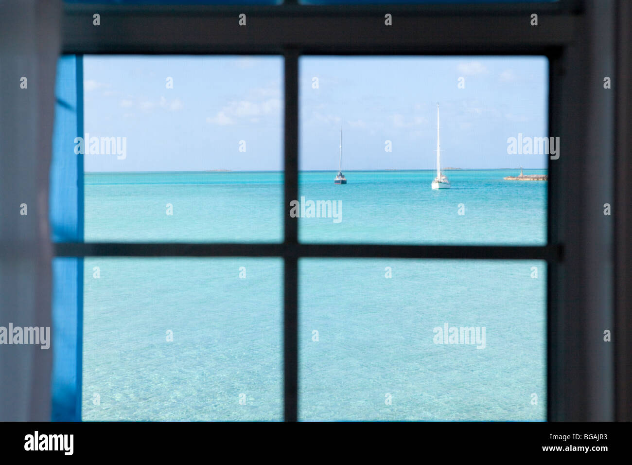 Guardando fuori della finestra su barche sul verde blu dei Caraibi acque Foto Stock