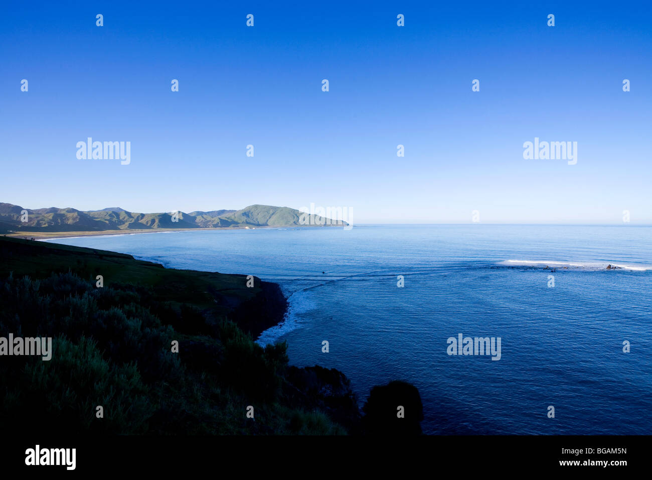 Vista Mare del Sud Wairarapa Bay Nuova Zelanda mare di rottura su roccia con il blu del cielo Foto Stock