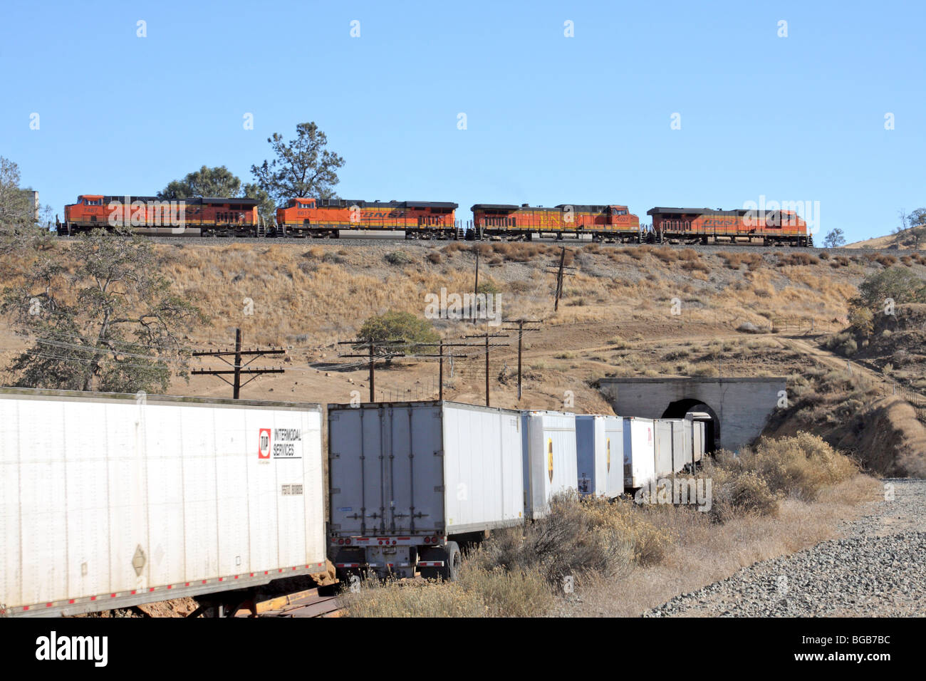 Un eastbound BNSF treno merci passa al di sopra di sé al loop di Tehachapi tra Bakersfield e Mojave, California. Foto Stock