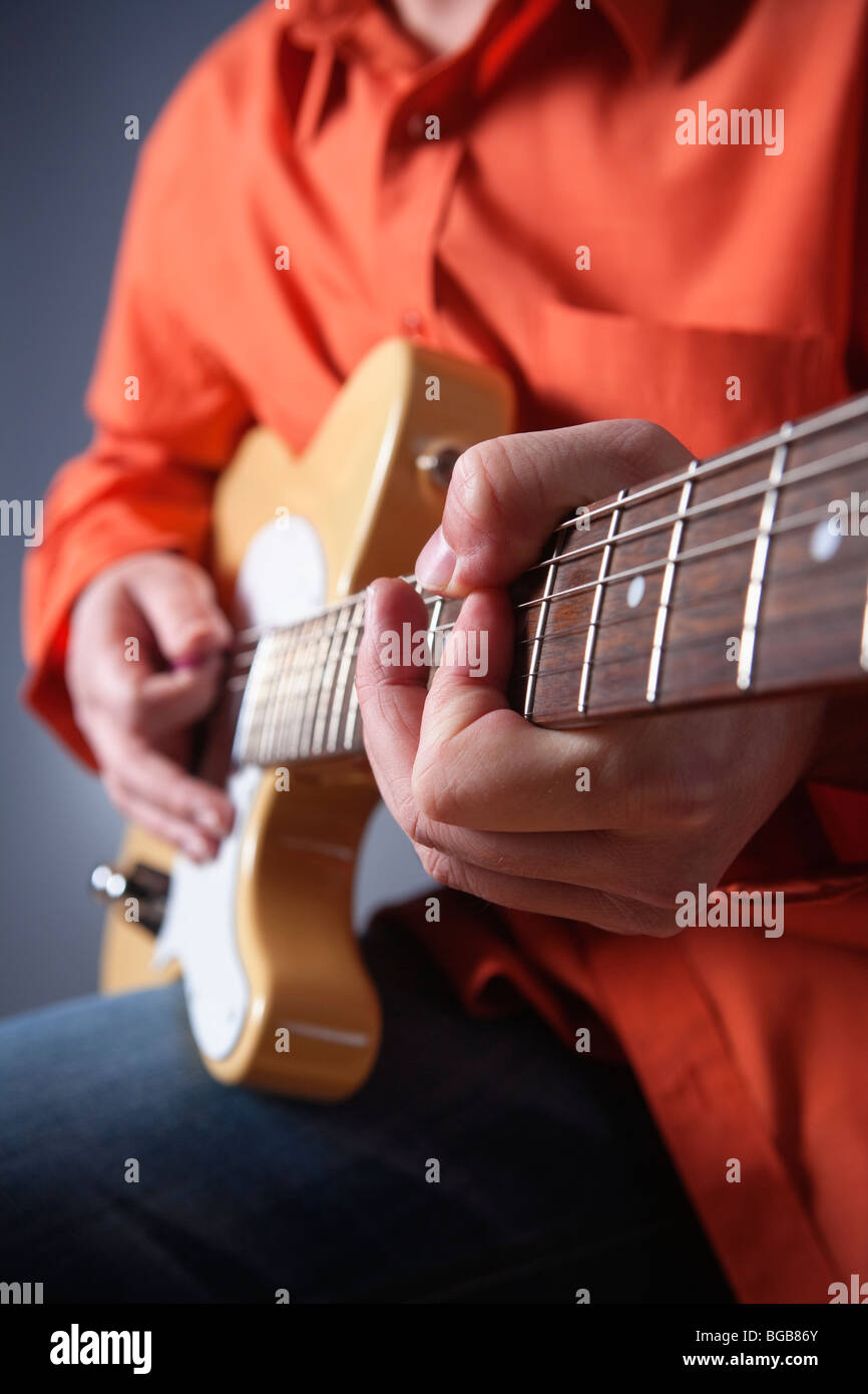 Primo piano delle mani di un musicista di suonare una chitarra elettrica Foto Stock