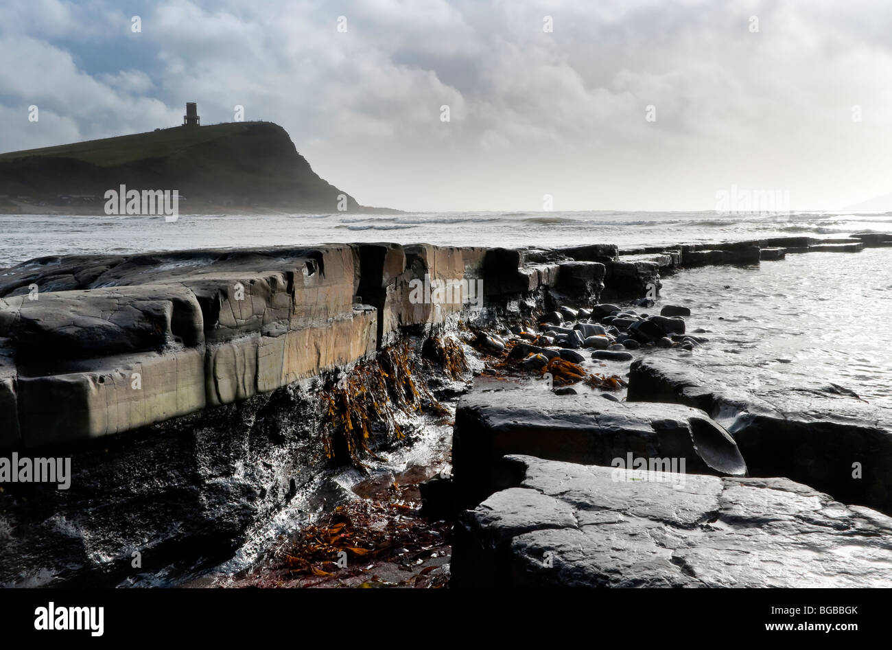 Sporgenza di roccia andando per mare a Kimmeridge Dorset, parte della Jurassic costa. Clavell torre in background Foto Stock