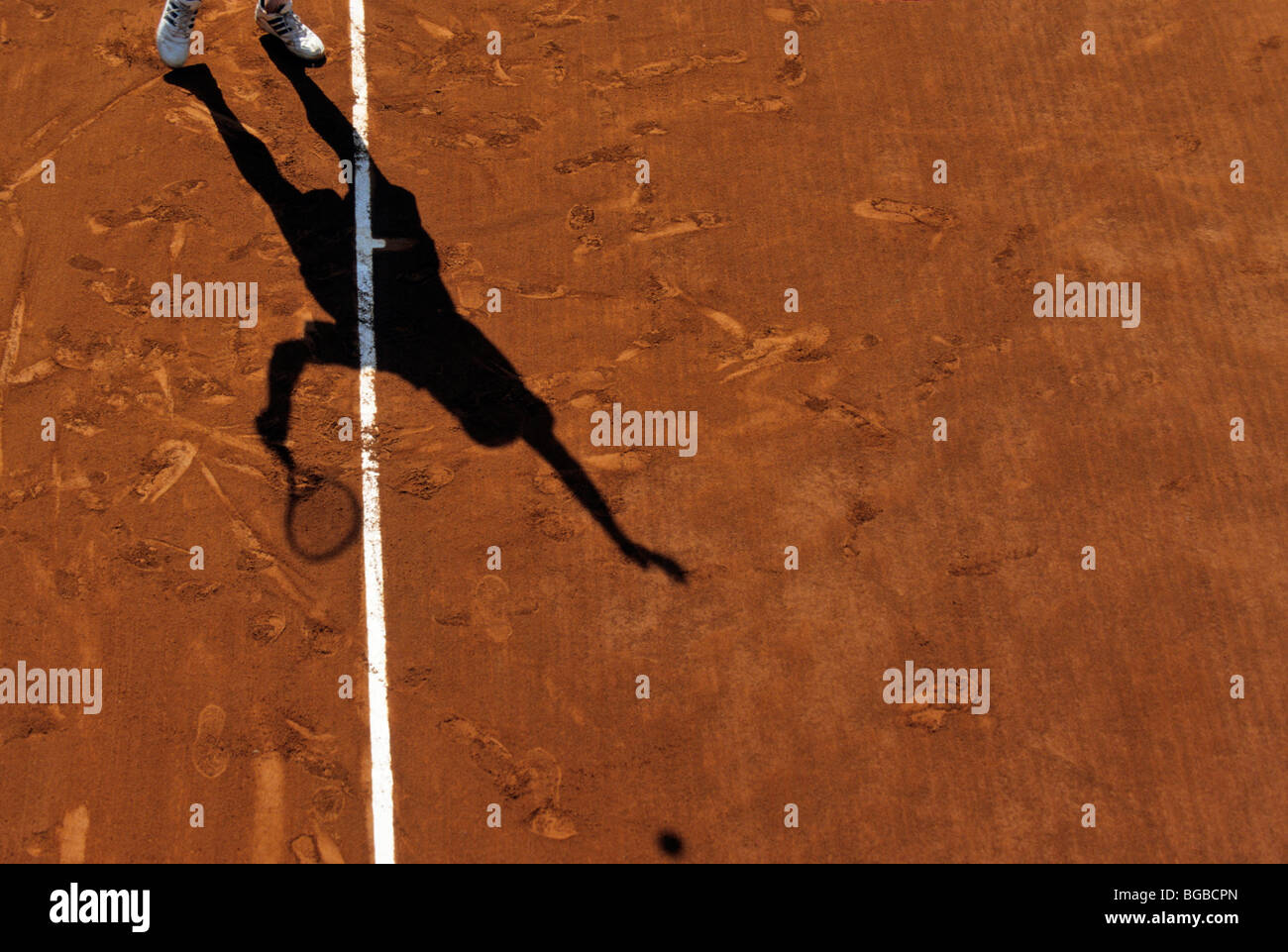 Ombra di un giocatore di tennis su una argilla corte circa per servire Foto Stock