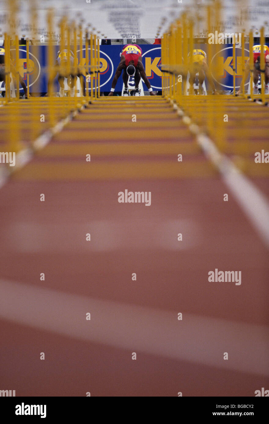 Vista attraverso gli ostacoli della preparazione degli atleti per 100m gara Foto Stock