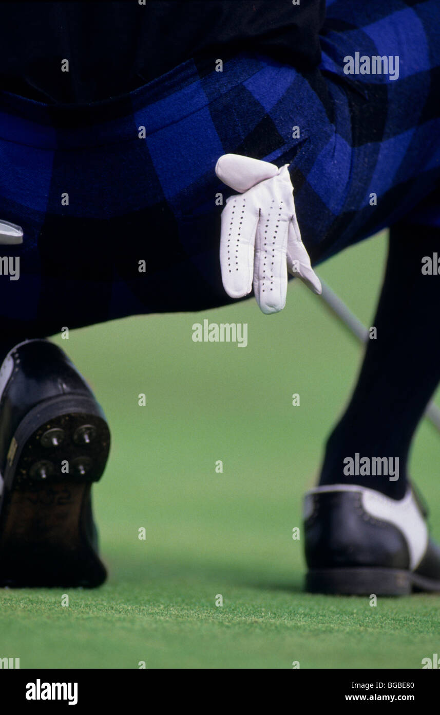 Il Golfer indossando plus fours accucciato giù per analizzare la sua shot Foto Stock