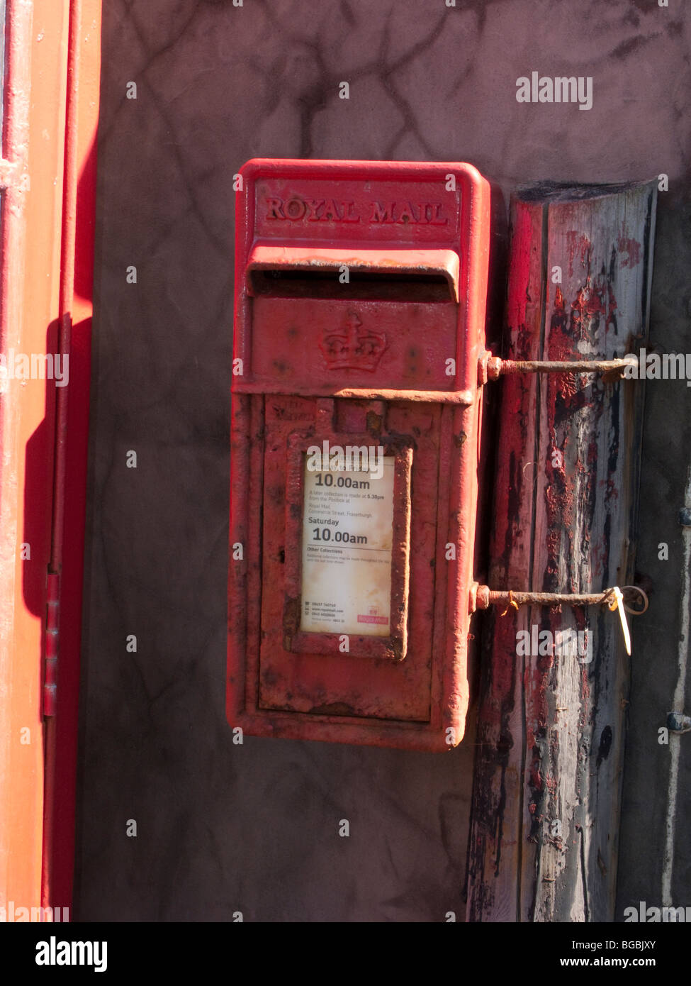 Chiusura del vecchio telefono rosso scatola e casella postale a fronte mare Pennan, Aberdeenshire, Scozia Foto Stock