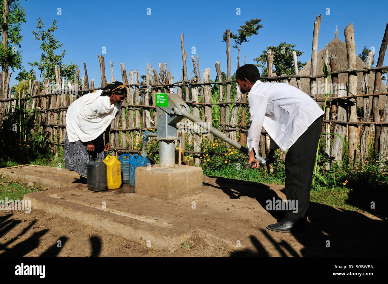 Popolo africano il pompaggio di acqua in corrispondenza di una nuova costruzione pompa dell'acqua, Rift Valley, Oromia, Etiopia, Africa Foto Stock