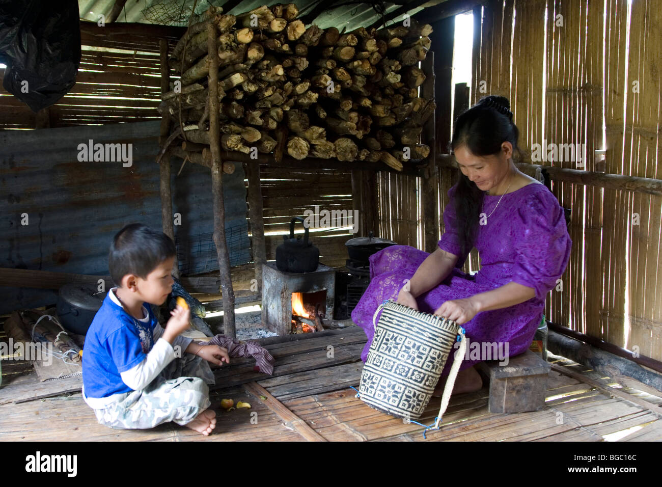 Un Penan madre e figlio nella loro casa, una piccola capanna costruita in legno e bambù e il materiale di scarto nel Borneo malese. Foto Stock