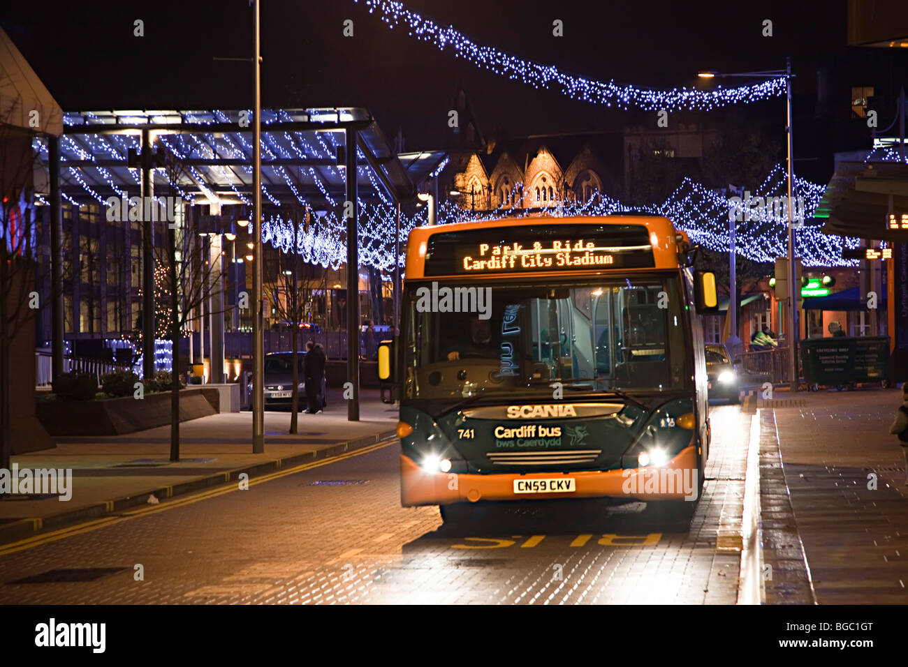 I mezzi di trasporto pubblico bus di notte in centro città con decorazioni di Natale Cardiff Wales UK Foto Stock