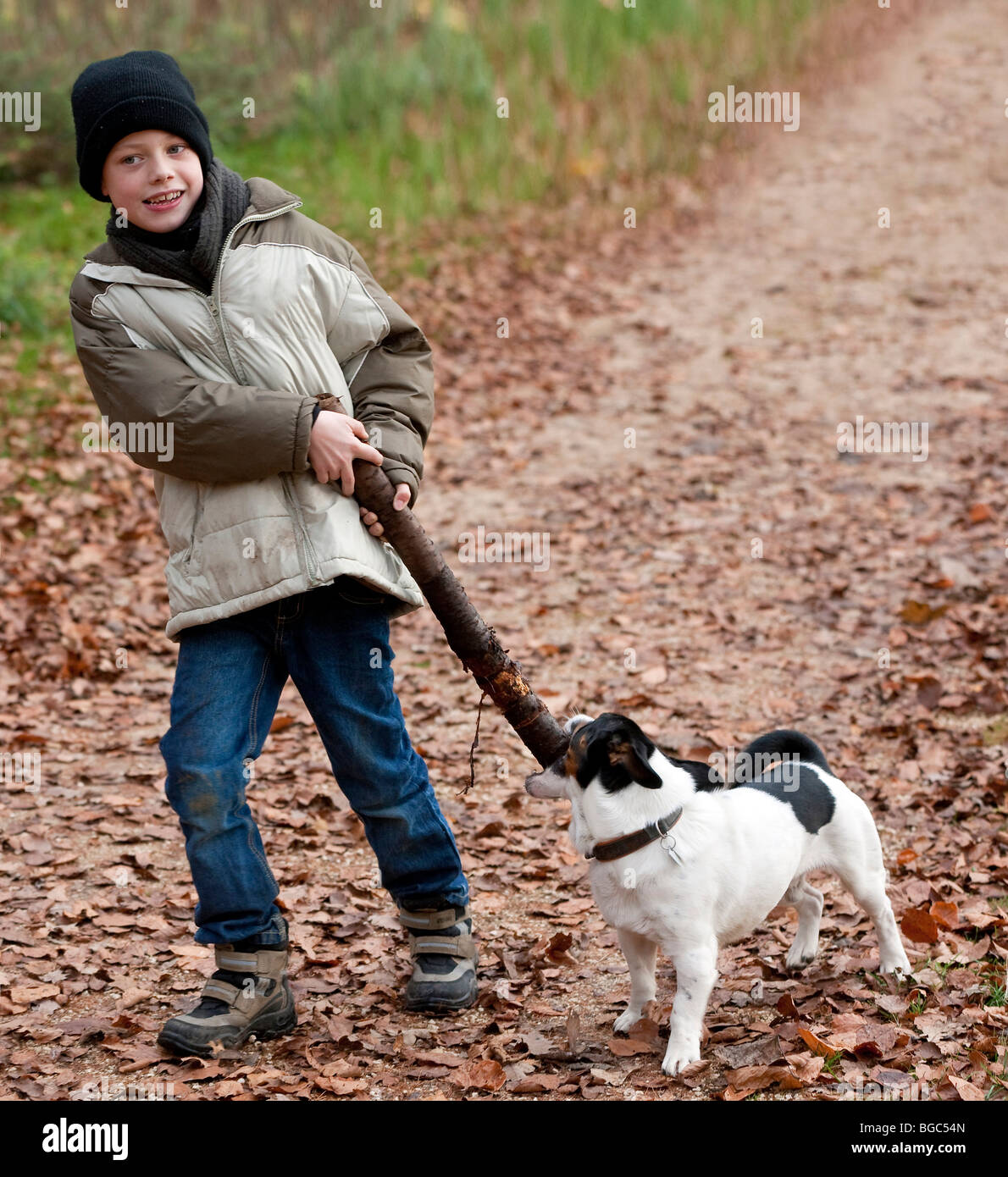 Un ragazzo, 7 anni, giocando con il suo cane Foto Stock