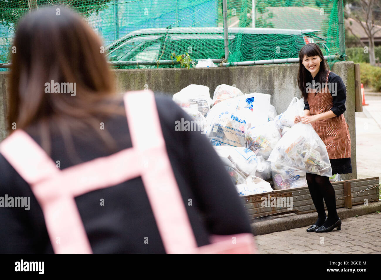 Giovani donne saluto ogni altro a drop off site Foto Stock