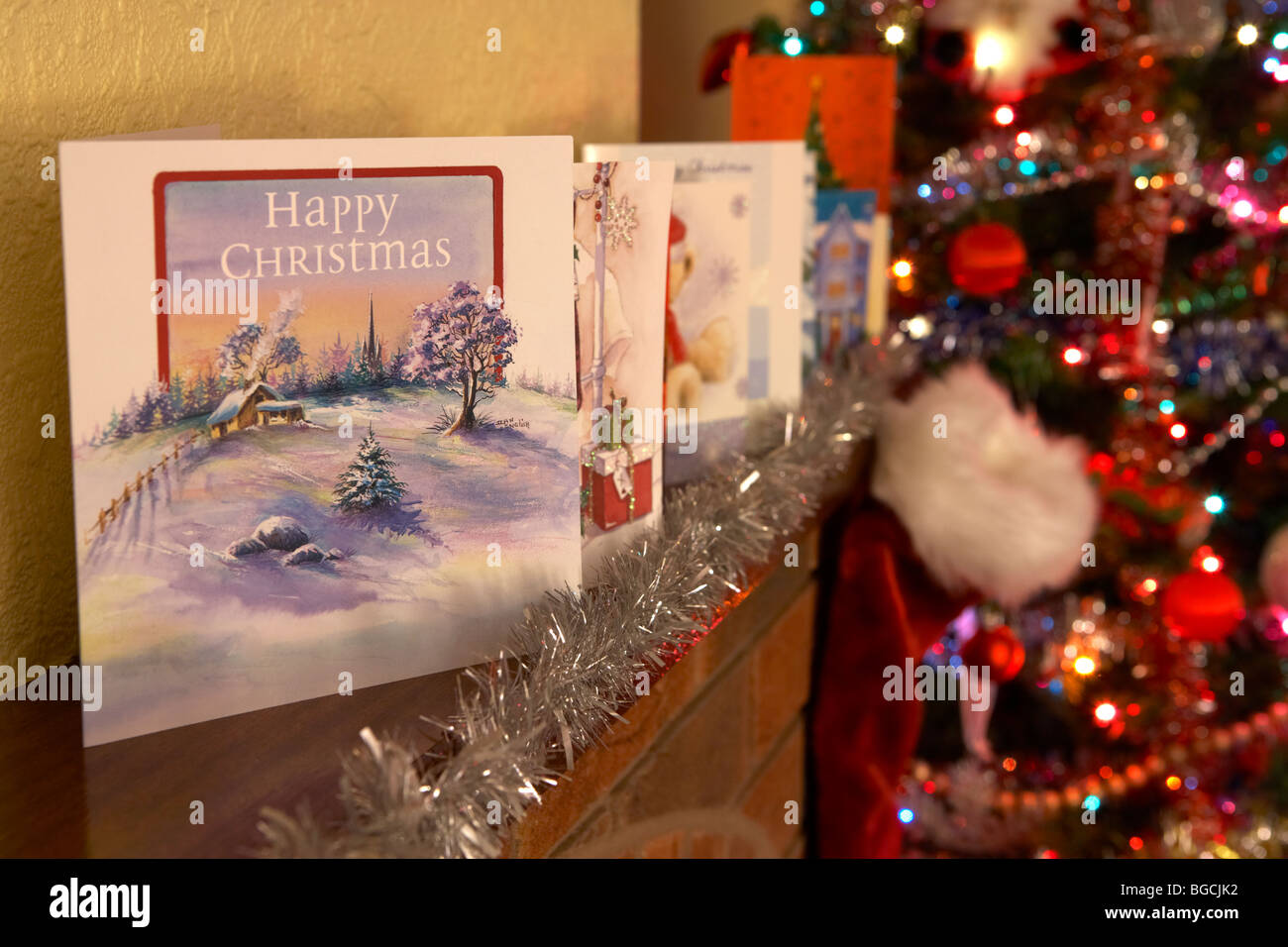 Fila di carte di natale su un da caminetto in un Natale decorato soggiorno nel Regno Unito Foto Stock
