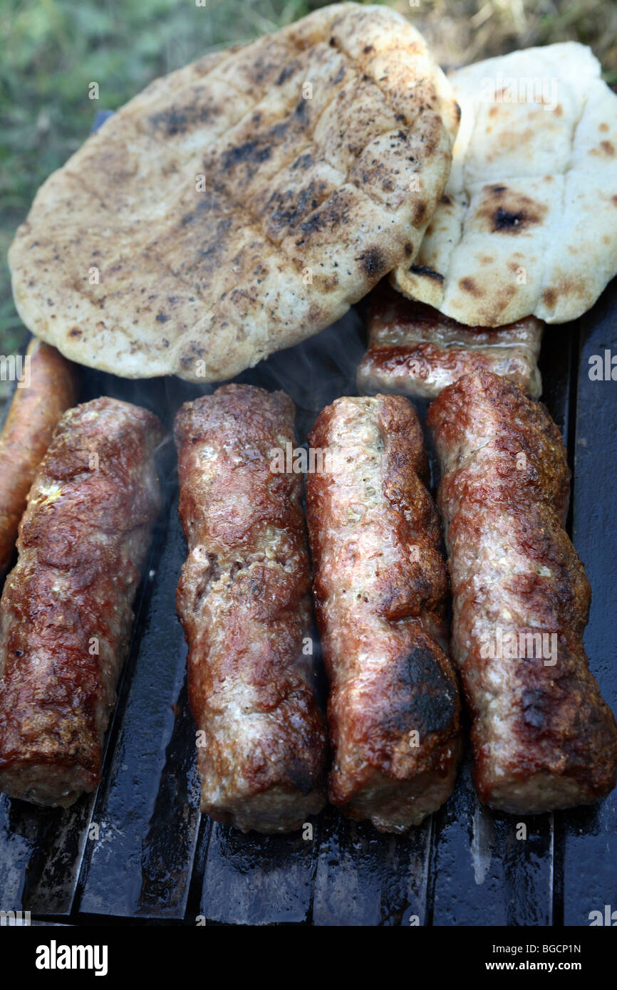 Barbecue. "Sis kebab", carni macinate rotoli la tostatura su hot barbeque piastra con "somun" pane tagliato in due. Foto Stock