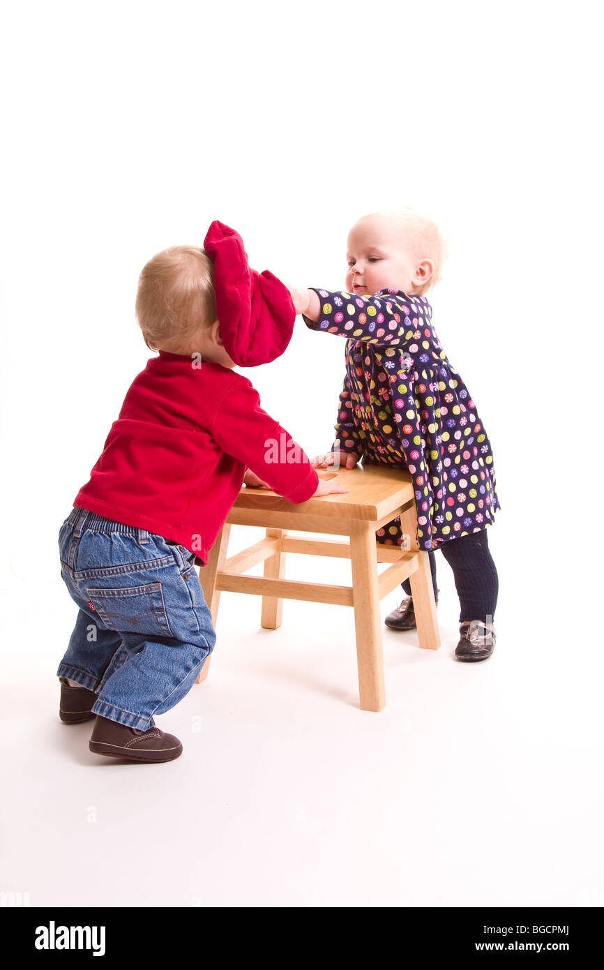 1 anno di età gemelli divertendosi isolato su bianco Foto Stock