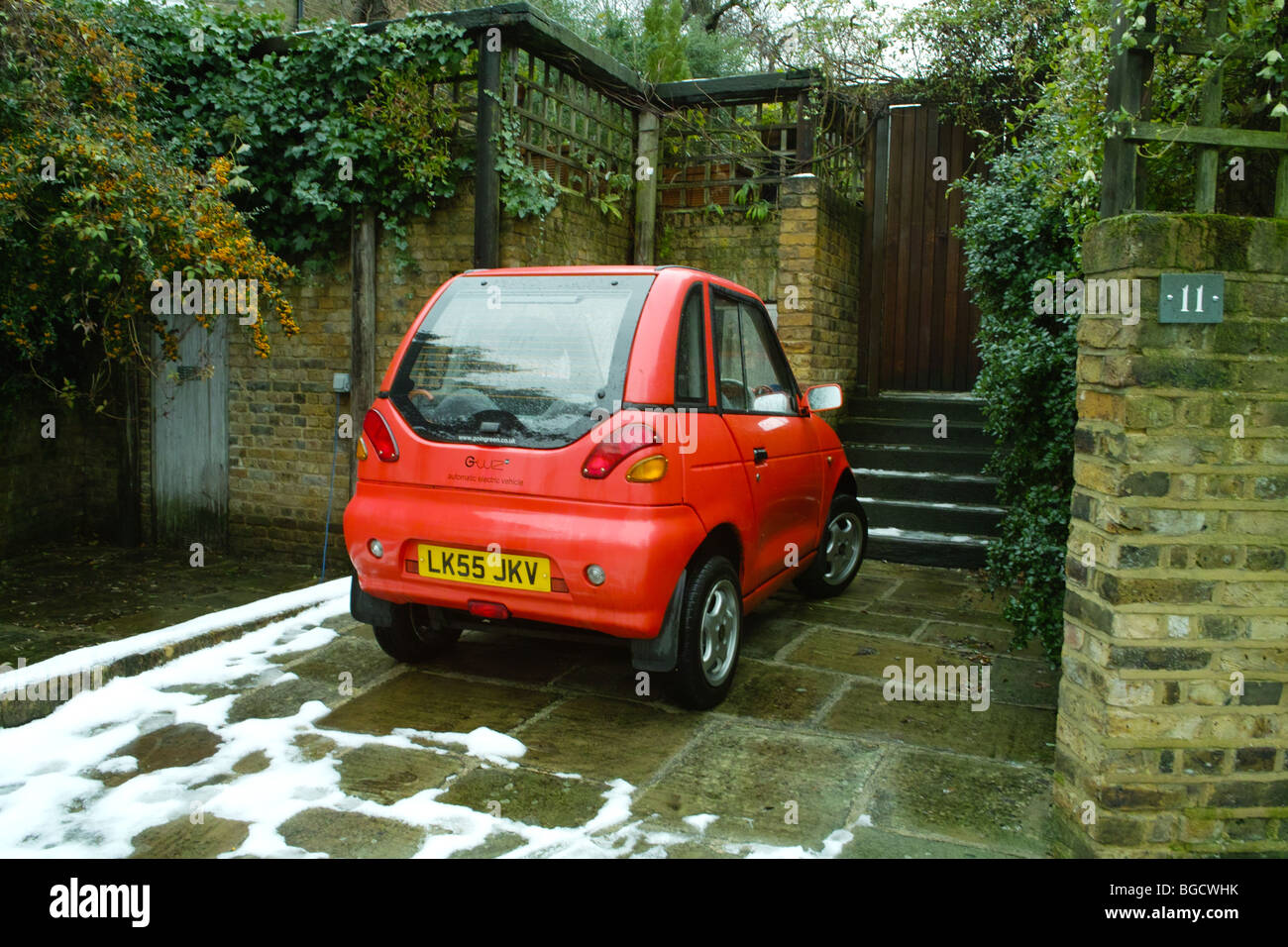 G Wiz GWiz G-Wiz pulita batteria verde con motore elettrico veicolo auto parcheggiate in strada residenziale road spazio parcheggio drivew privato Foto Stock