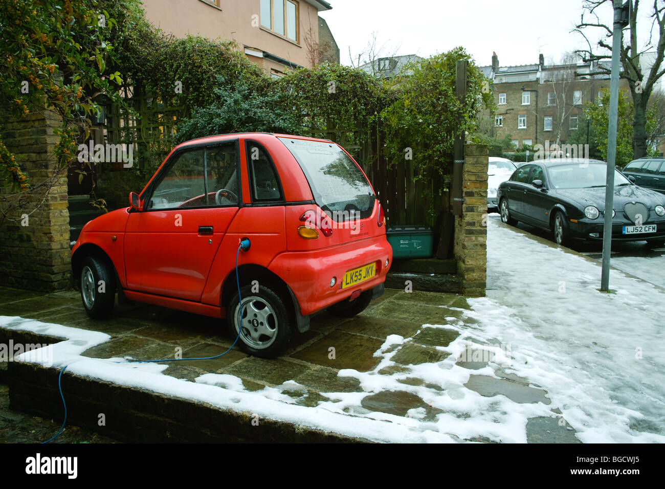 G Wiz GWiz G-Wiz pulita batteria verde con motore elettrico veicolo auto parcheggiate in strada residenziale road spazio parcheggio drivew privato Foto Stock