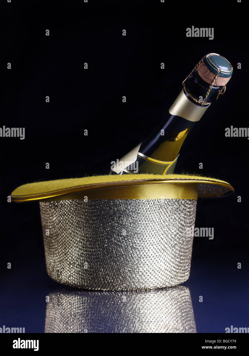 Bottiglia di champagne nel golden top hat su blu scuro superficie Foto Stock