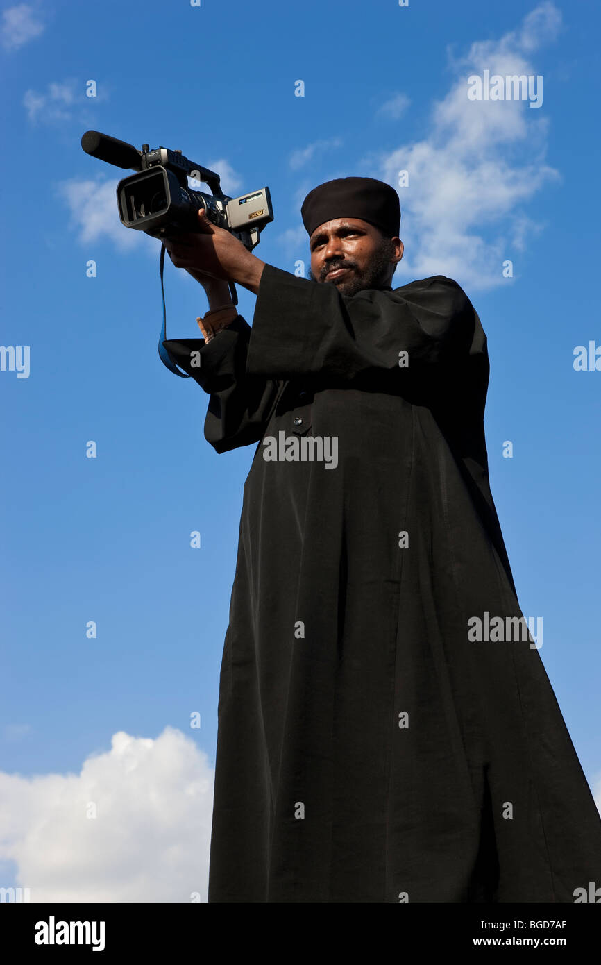 Sacerdote con videocamera, Timket (celebrazione di Epithany, cristiano-ortodossa) ad Addis Abeba, Etiopia Foto Stock