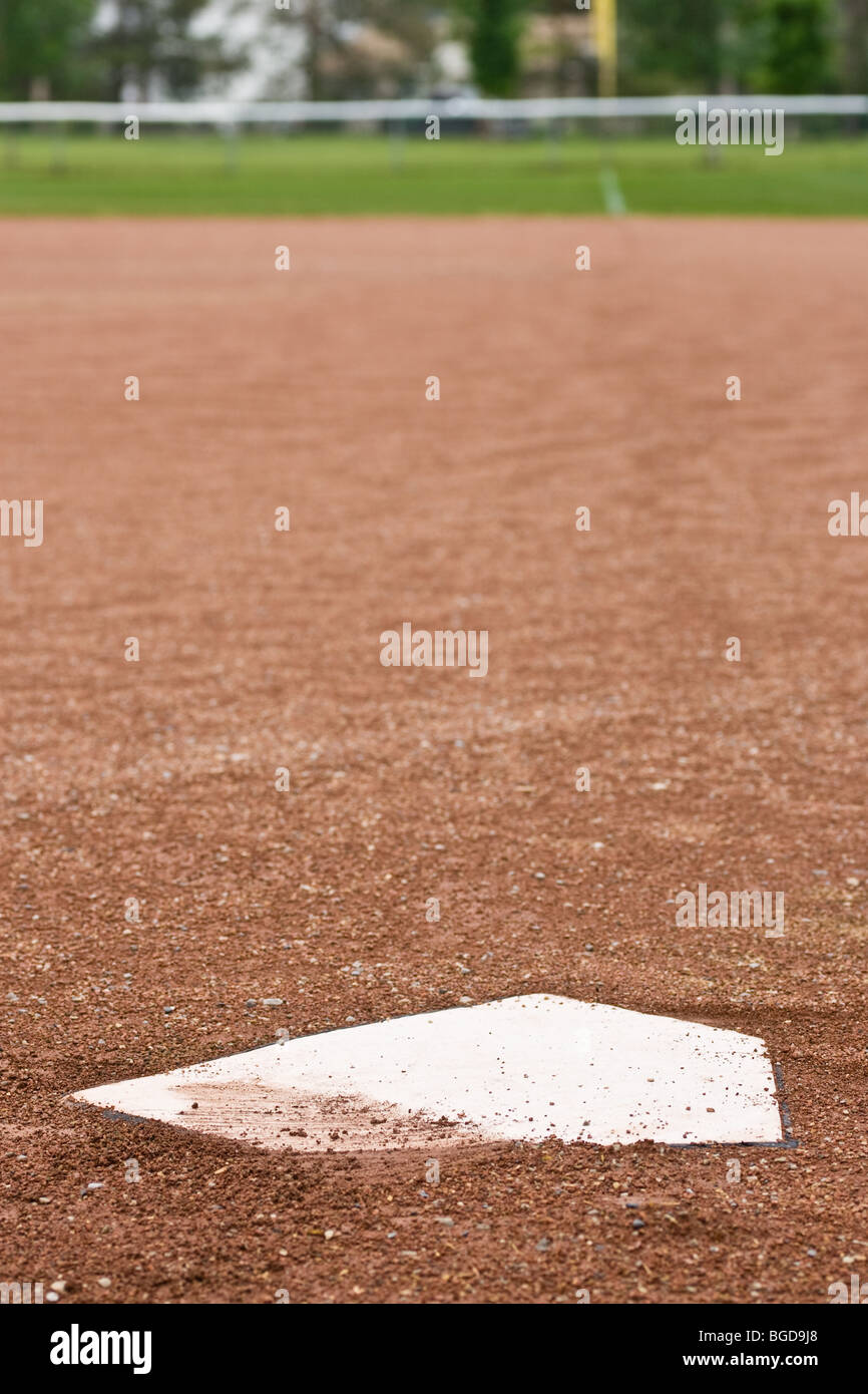 Un primo piano della piastra iniziale a un diamante di baseball, guardando fuori alla prima linea di base verso il fuori campo lato. Foto Stock