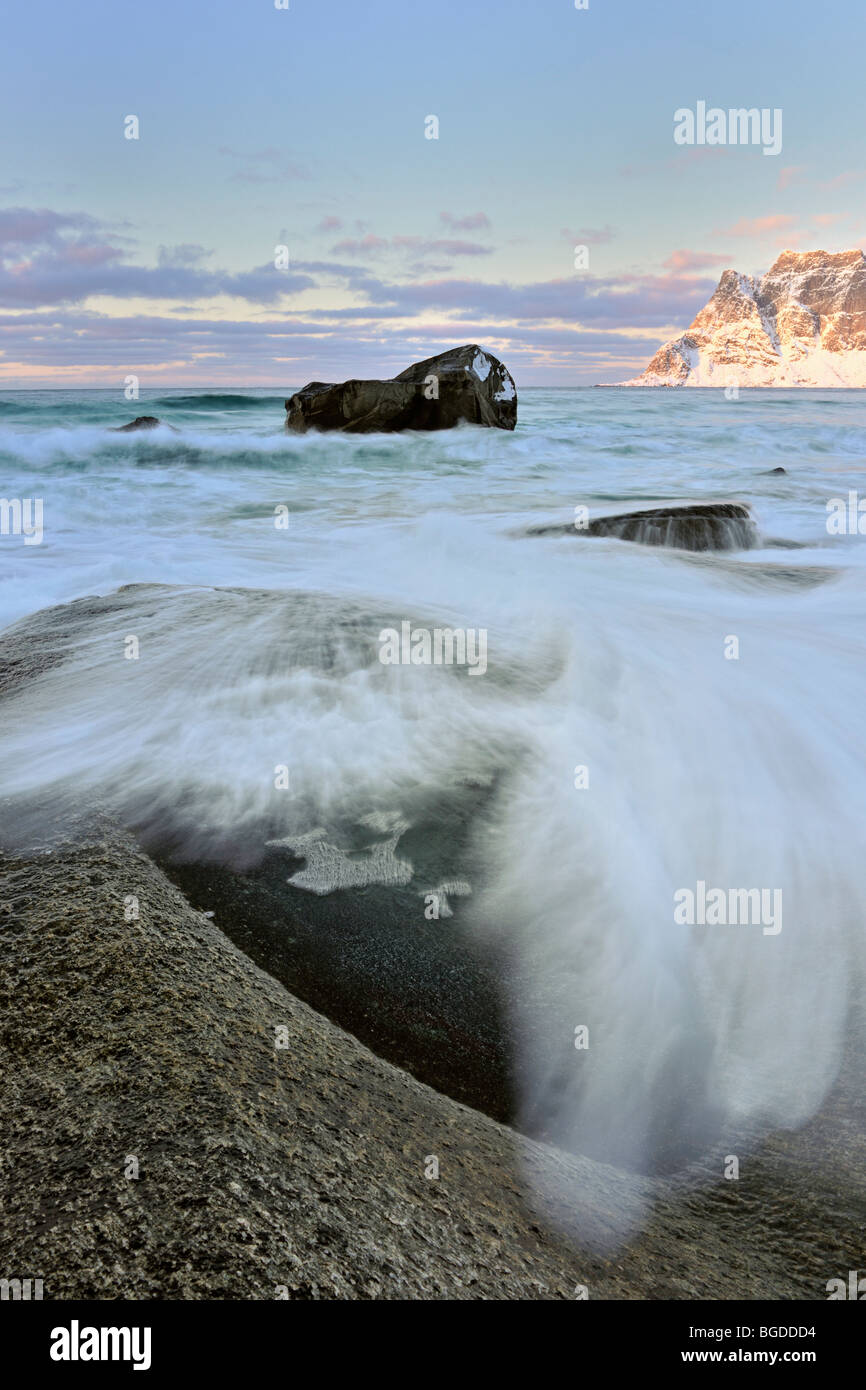 Un'onda dal mare agitato colpisce la nuda roccia sulla riva. Da Utakleiv nelle isole Lofoten, a nord della Norvegia. Foto Stock