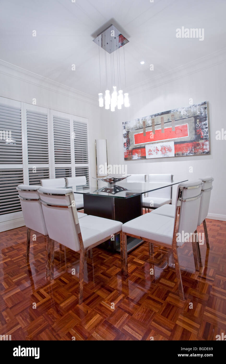 Casa lussuosa sala da pranzo interno con il marrone scuro pavimenti in legno e in pelle bianca mobili da pranzo Foto Stock