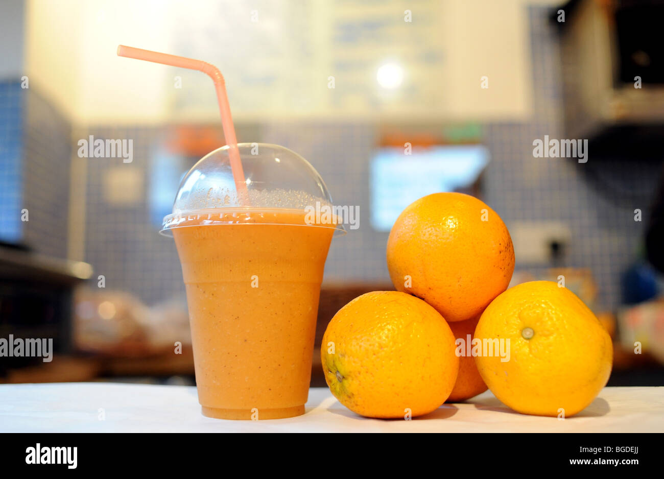 Un sano frullato arancione a bere con una cannuccia piena di vitamina c Foto Stock