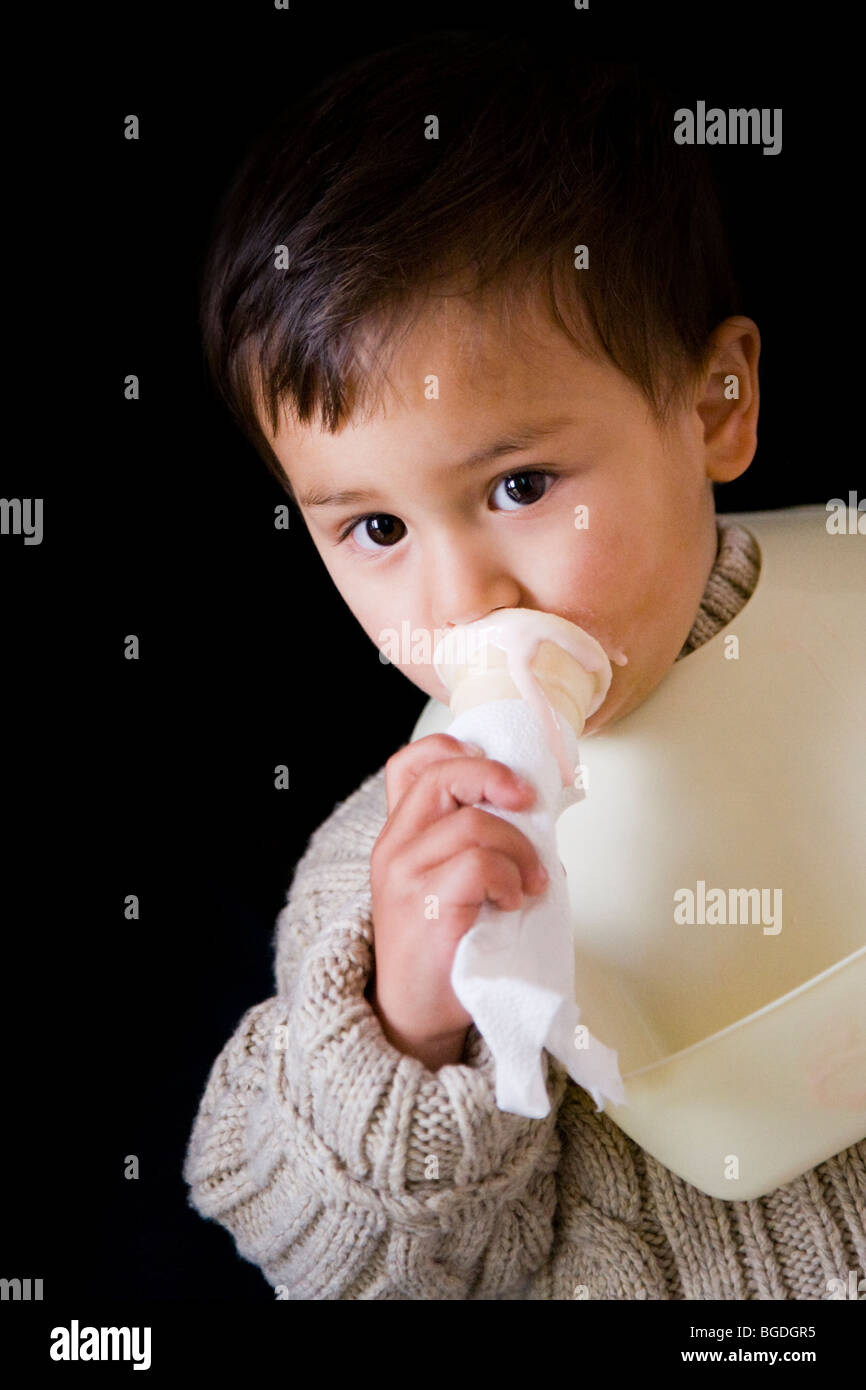 21 mesi o. boy mangiare gelato da un cono. Foto Stock