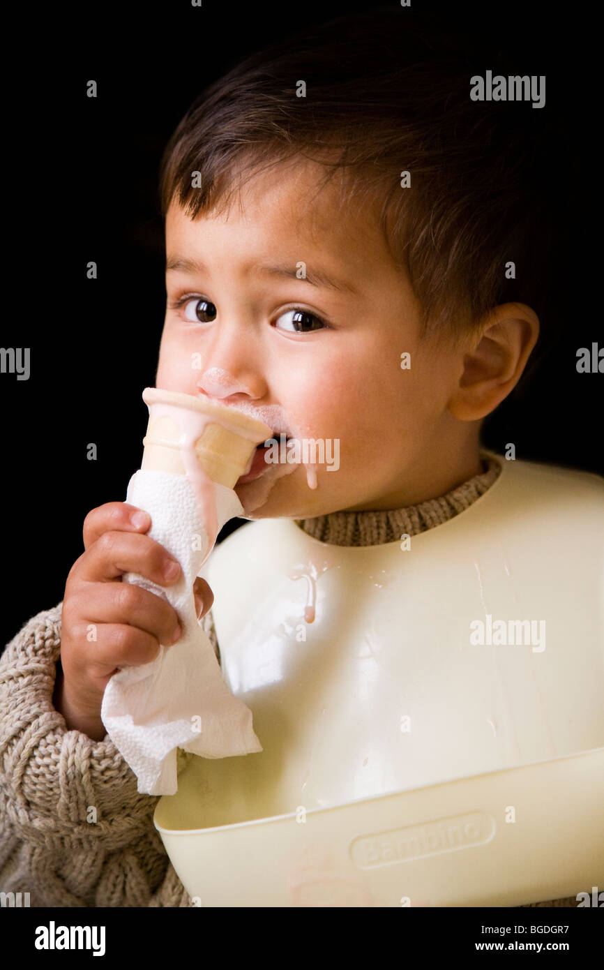 21 mesi o. boy mangiare gelato da un cono. Foto Stock