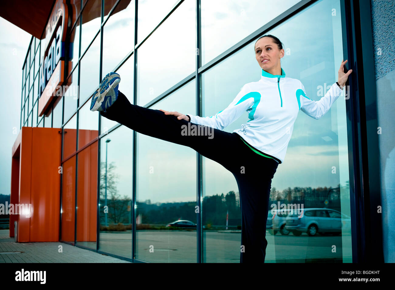 Giovane donna in fase di riscaldamento per jogging Foto Stock