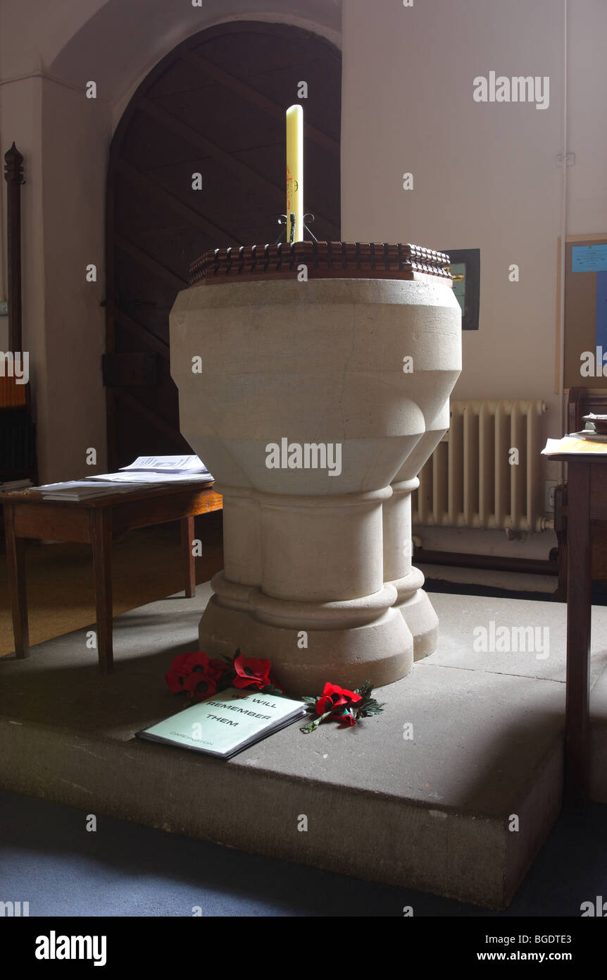 Splendidamente illuminata fonte battesimale in pietra del St James chiesa nel tranquillo villaggio di Cardington nello Shropshire,Inghilterra. Foto Stock