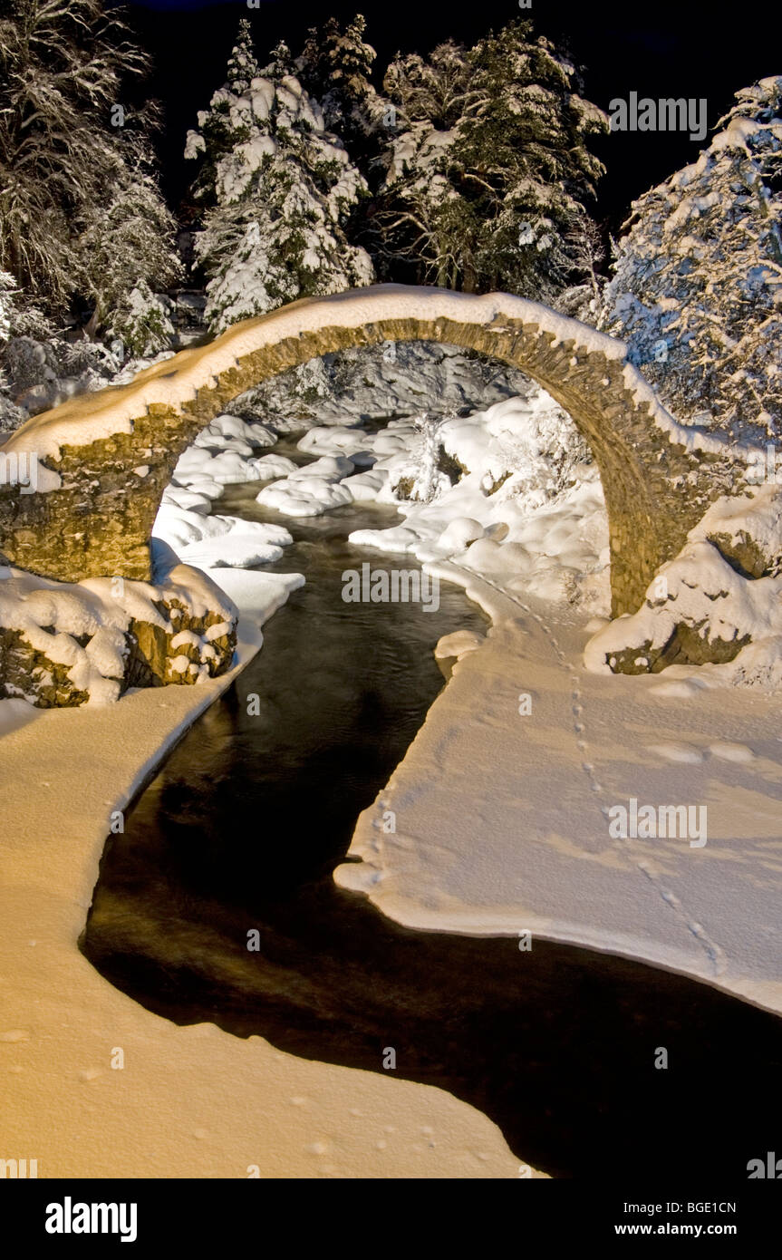 Il Packhorse Bridge a Carrbridge illuminate in inverno la neve Strathspey Inverness-shire Highland scozzesi. SCO 5722 Foto Stock