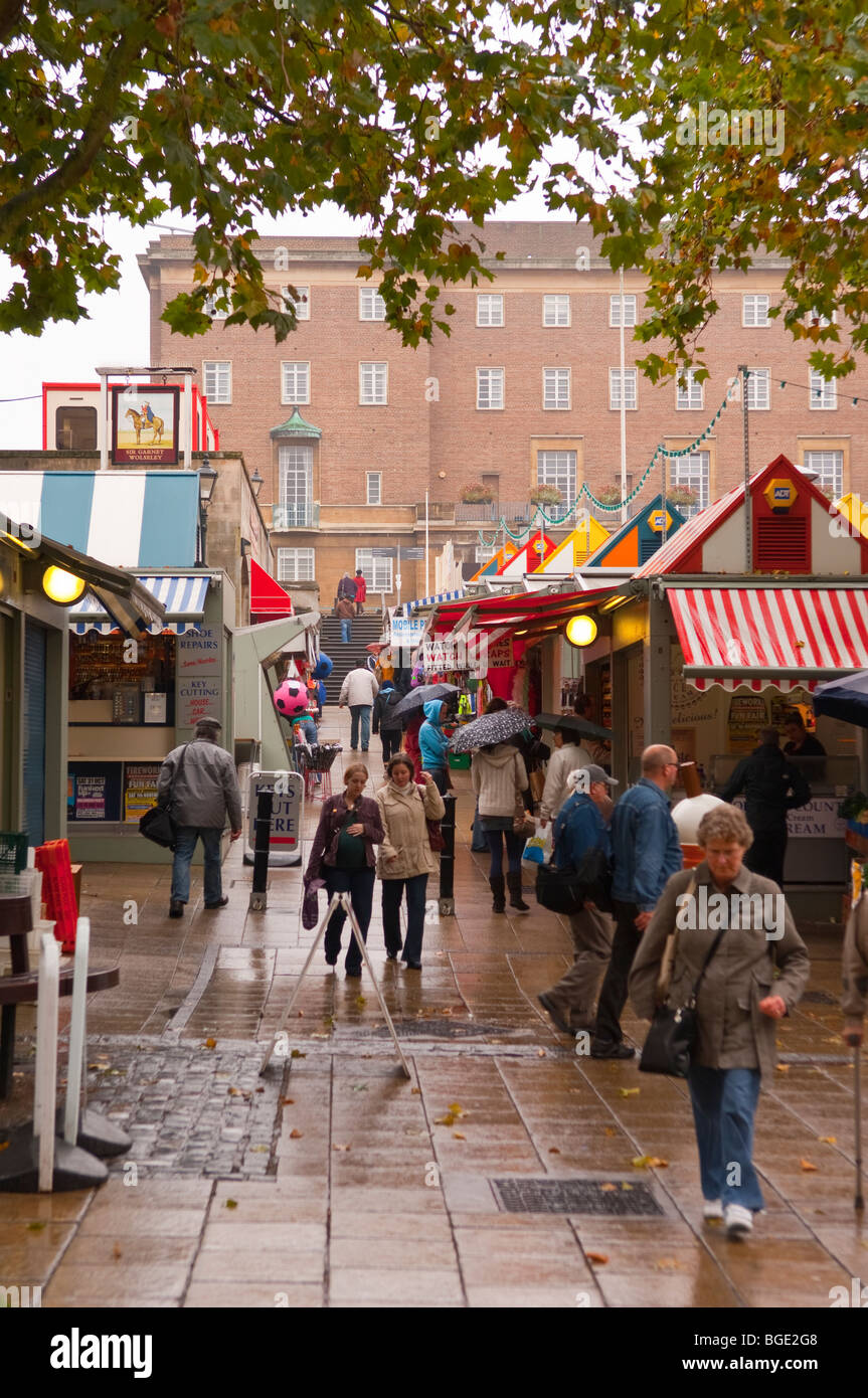 Gli amanti dello shopping sotto la pioggia nei pressi del mercato all'aperto nel centro della città di Norwich, Norfolk, Regno Unito Foto Stock