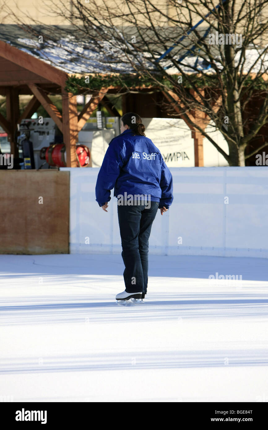 Giovane donna adulta Ice membro dello staff pattinaggio su una pista di pattinaggio all'aperto Foto Stock