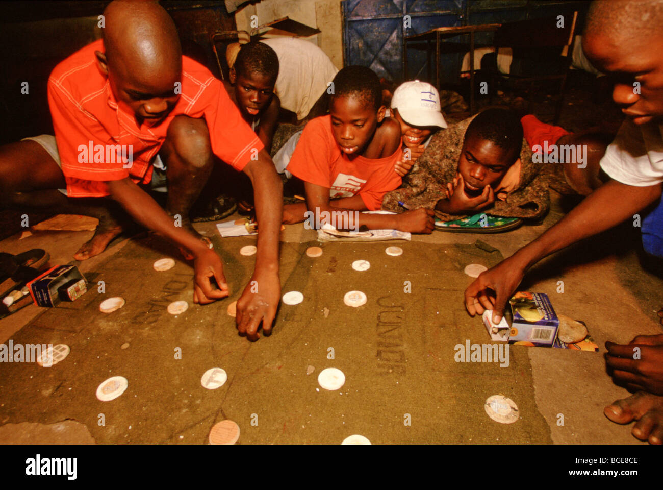 Ragazzi giocare una partita di calcio da tavolo utilizzando fatti in casa a base di pezzi in un centro di accoglienza per bambini di strada di Luanda, in Angola Foto Stock