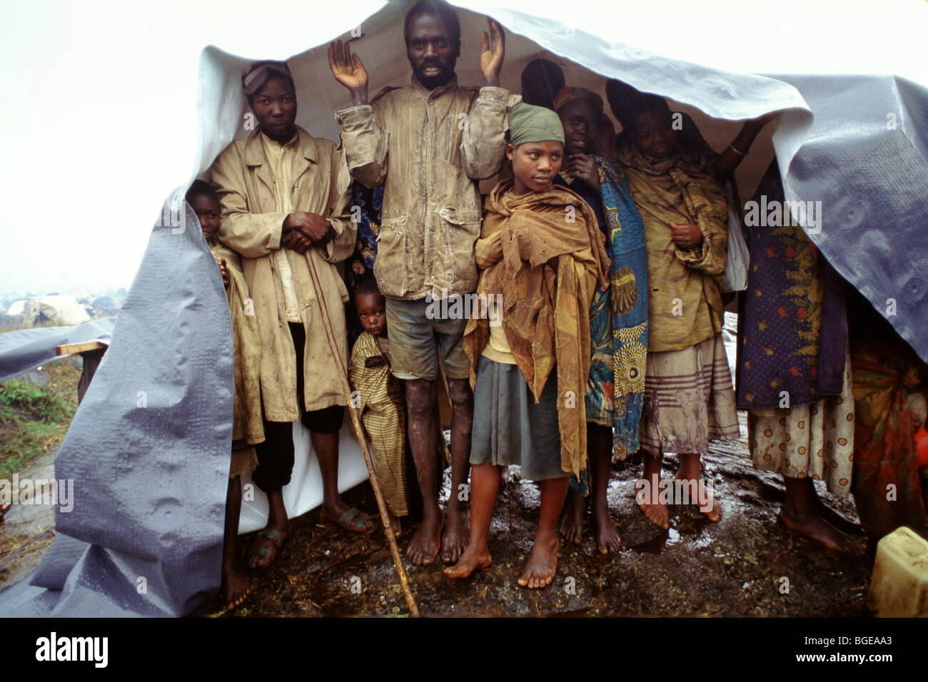 I rifugiati a Kibumba Camp, regione di Goma, Zaire, riparo dalla pioggia sotto un telone. Foto Stock
