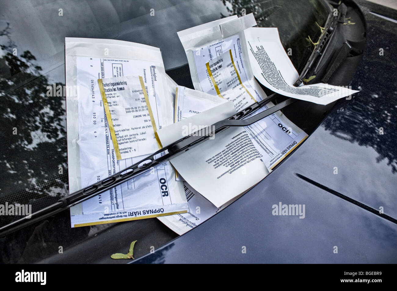 Una vettura scudo di vento coperto con sanzioni parcheggio parcheggio svedese biglietti Foto Stock