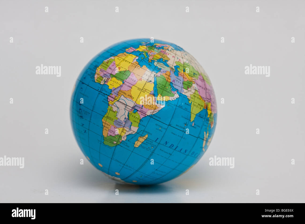Globo seduto su una scrivania sfondo bianco per la geografia di classe e di un libro di testo Foto Stock