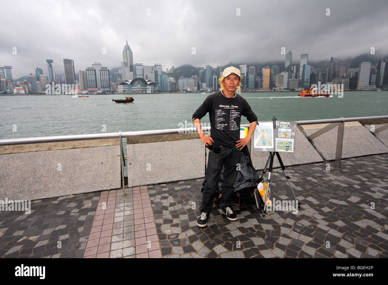 Steet fotografo sul lato di Kowloon di Victoria Bay cercando di fronte ai grattacieli di Isola di Hong Kong, Cina Foto Stock