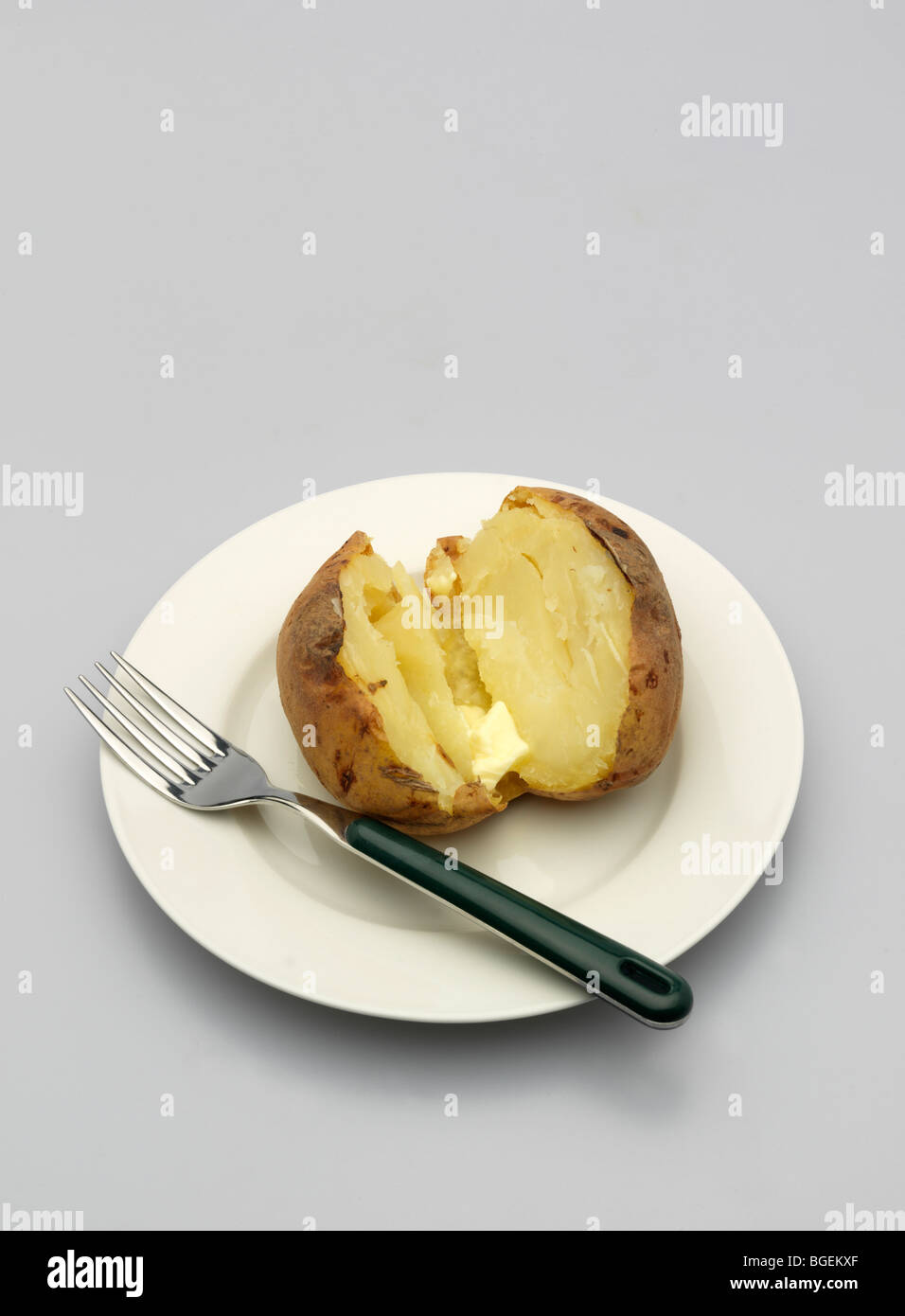 Patate cotte su una piastra bianca con una forchetta. Foto Stock