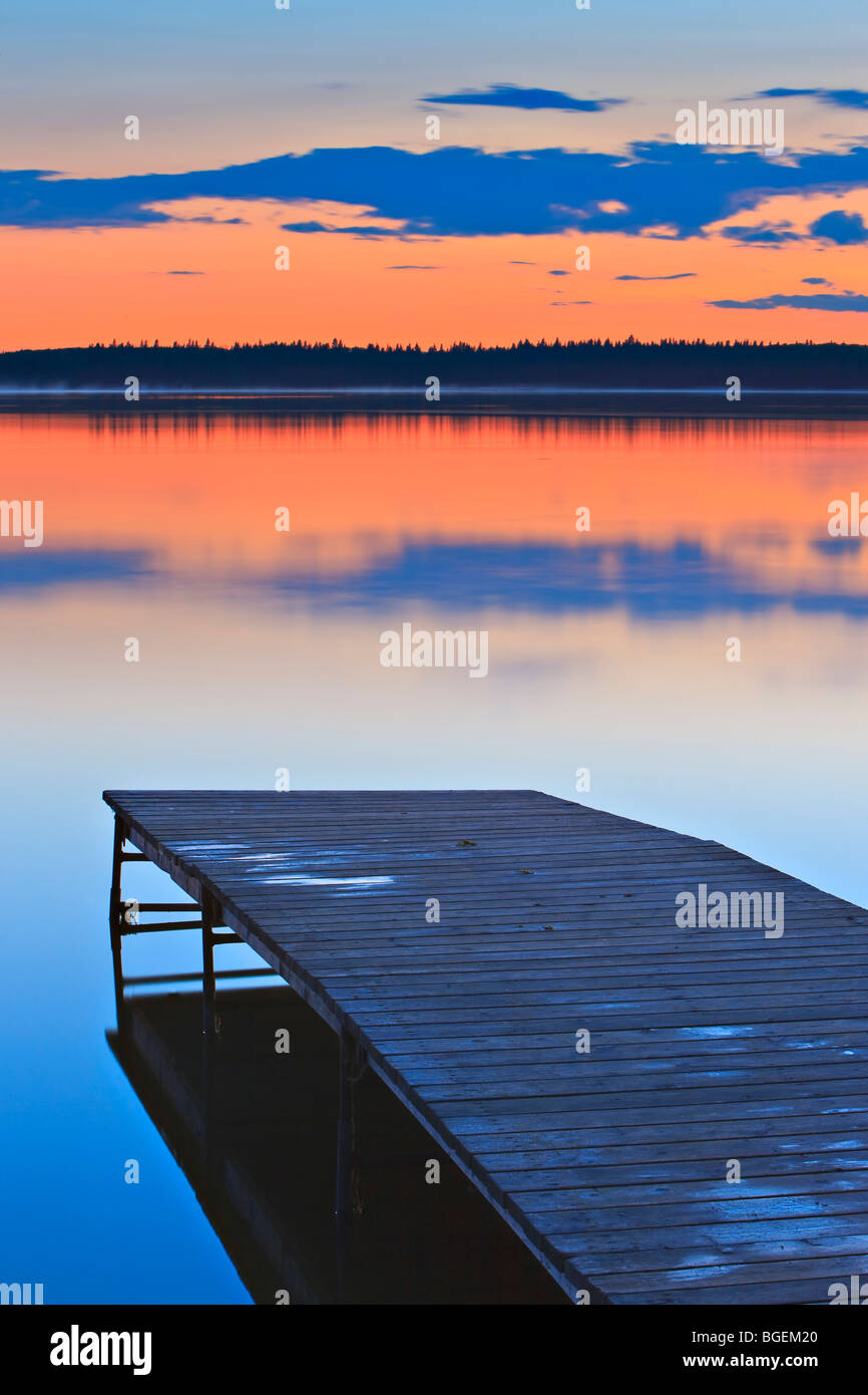 Tramonto su una banchina in legno su Lake Audy, Equitazione Mountain National Park, Manitoba, Canada. Foto Stock