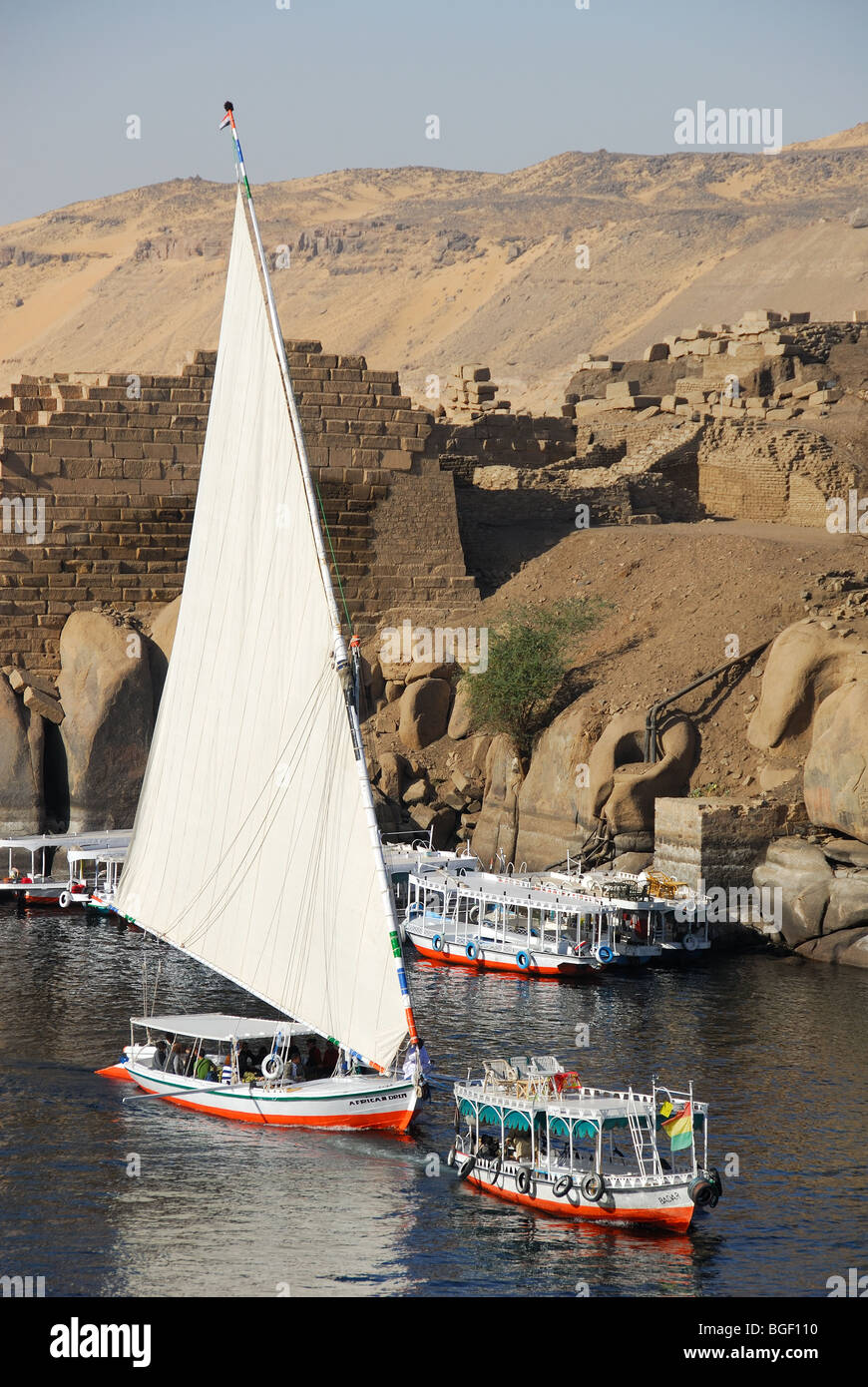 ASWAN, Egitto. Una feluca sul Nilo e river taxi vela passato antiche rovine sull isola Elefantina. 2009. Foto Stock