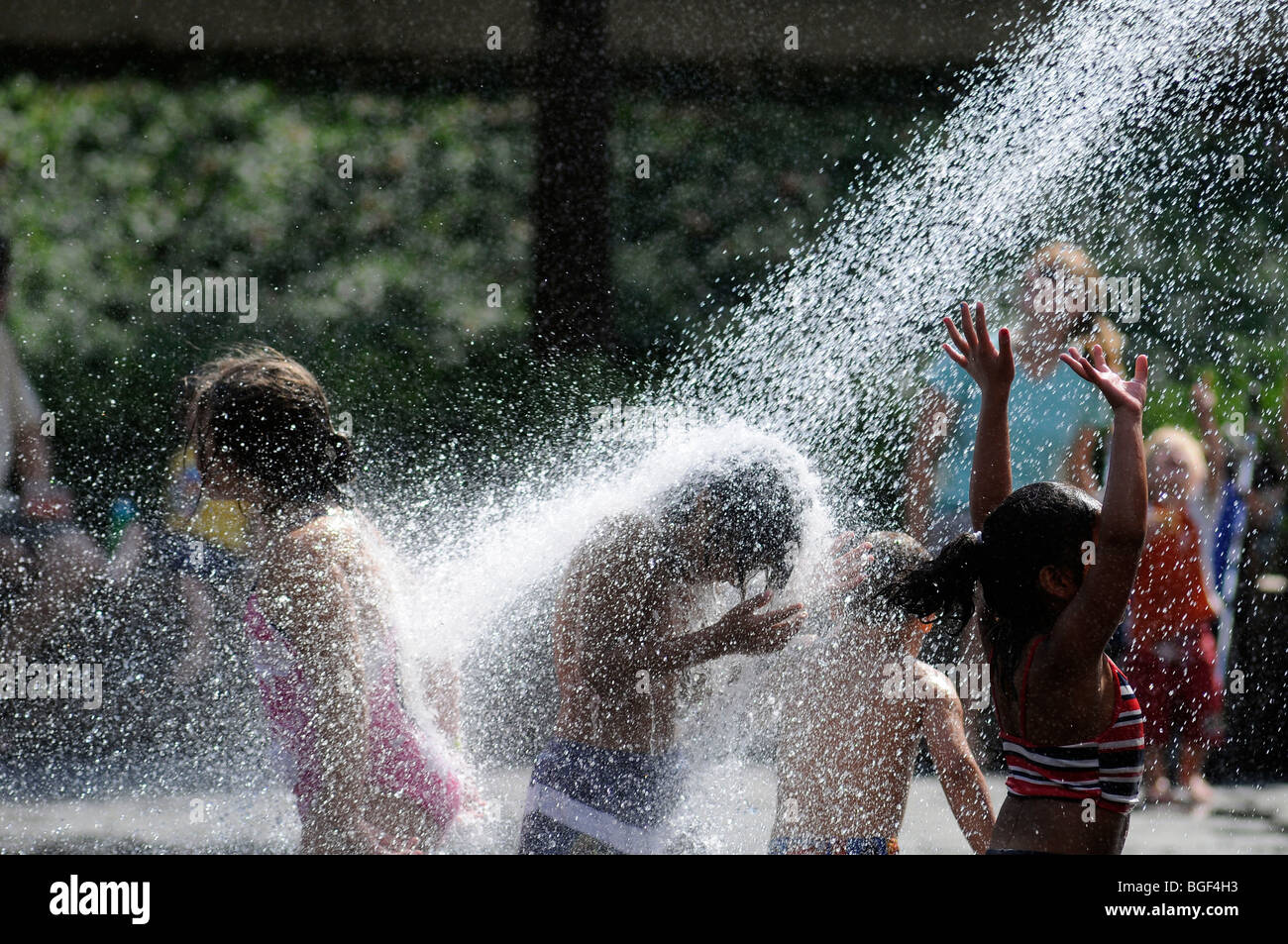 I bambini giocano in uno spruzzo di acqua dalla fontana di corona in Millennium Park di Chicago Foto Stock