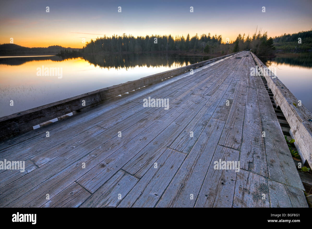Il vecchio ponte di legno che coprono l'entrata a Clayoquot braccio del Kennedy lago al tramonto, una zona di transizione del Clayoquot Sound UNE Foto Stock