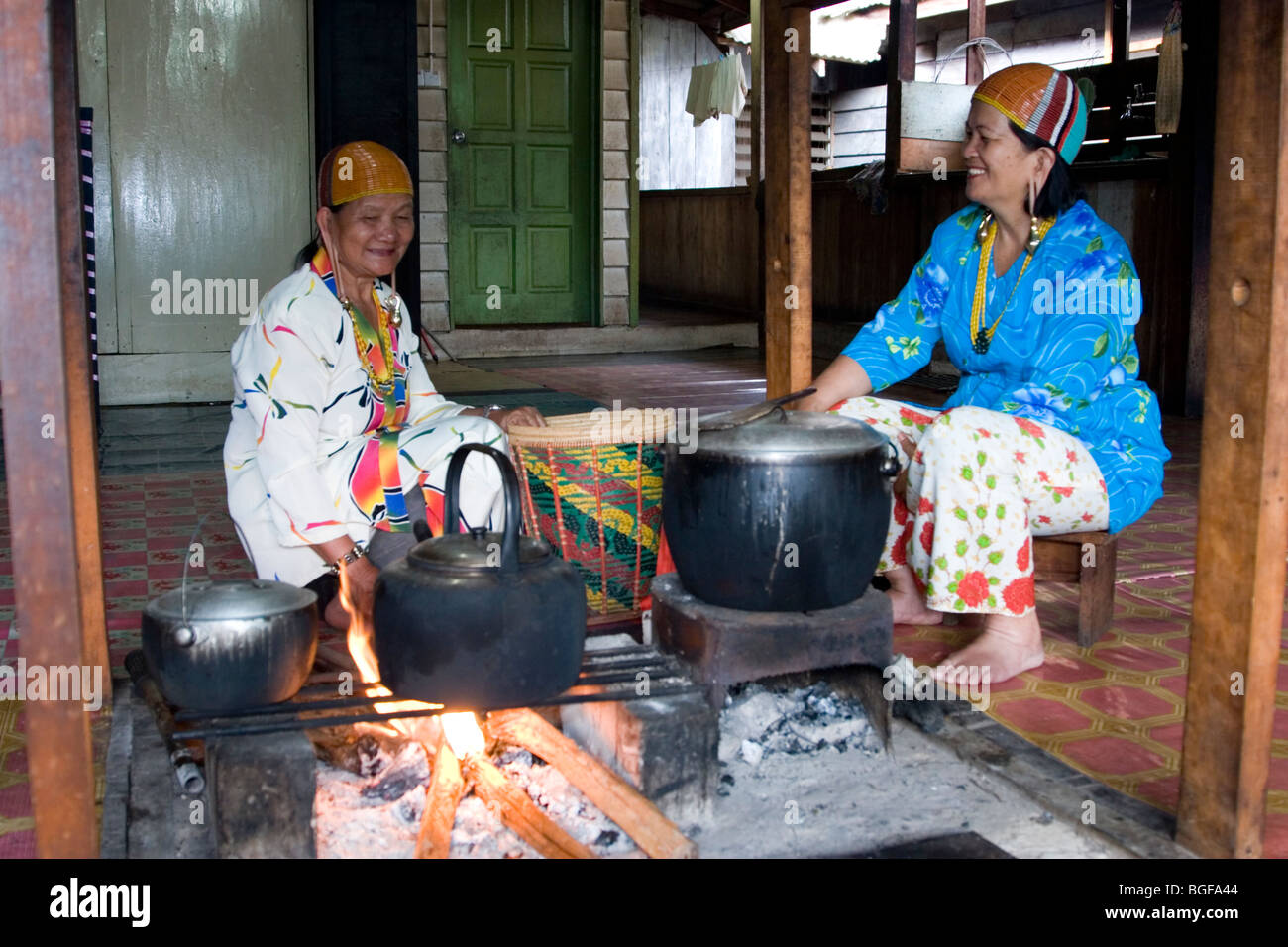 La gente per la cottura sul firepit del longhouse comunale del Barrio Asal nel Kelabit Highlands nel Borneo malese. Foto Stock